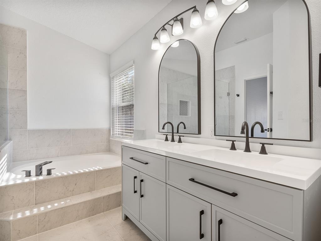 3215 Colusa Street Deltona, FL 32738 - Photo 23 of 32 a bathroom with a tub sink and mirror