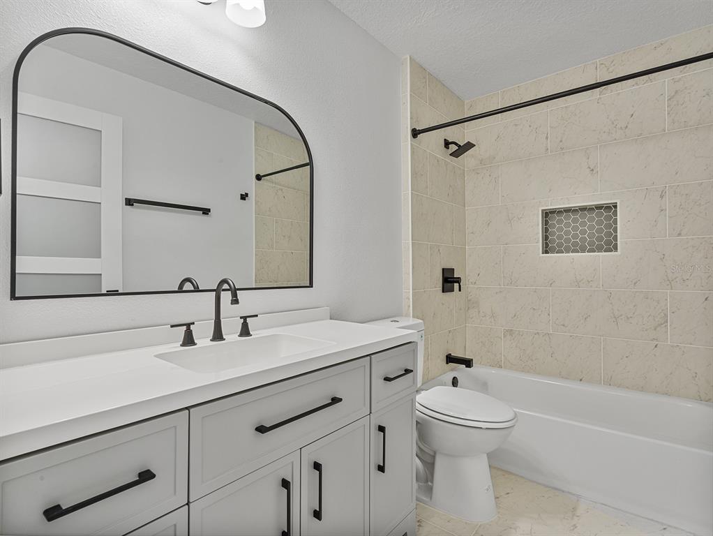 3215 Colusa Street Deltona, FL 32738 - Photo 27 of 32 a bathroom with a sink a toilet and shower