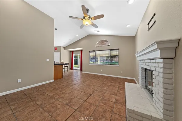 an empty room with windows and fireplace