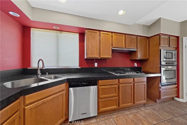 a kitchen with stainless steel appliances granite countertop a sink and a refrigerator