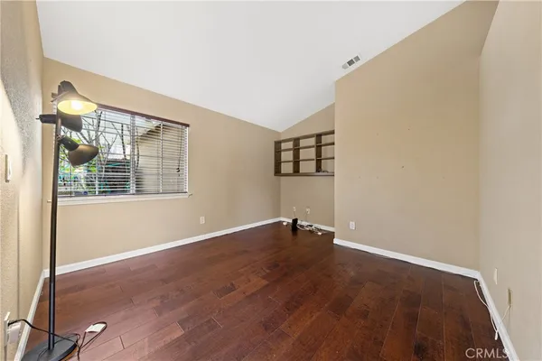 a view of empty room with wooden floor