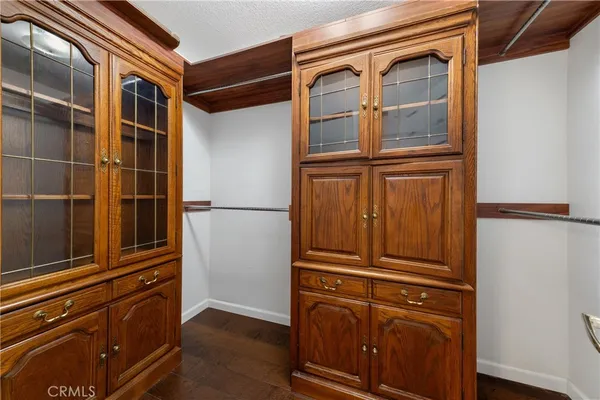 a view of an empty room with wooden floor and closet