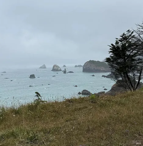 a view of a swimming pool with an outdoor seating and trees in the background