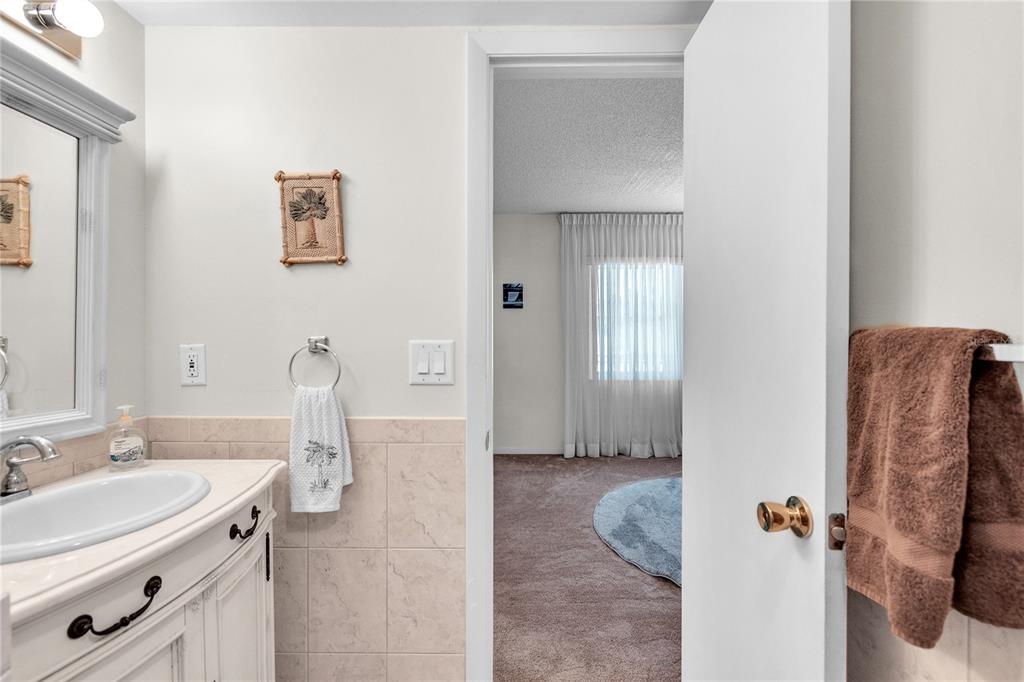 12200 Vonn Road, Unit 2206 Largo, FL 33774 - Photo 46 of 60 a bathroom with a granite countertop sink and a mirror