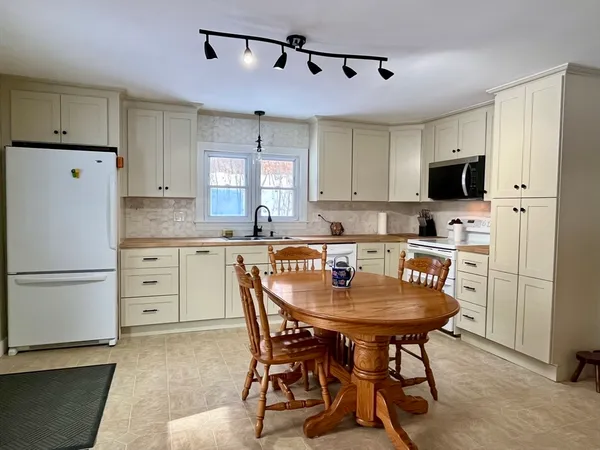 a kitchen with stainless steel appliances granite countertop a refrigerator and a stove top oven