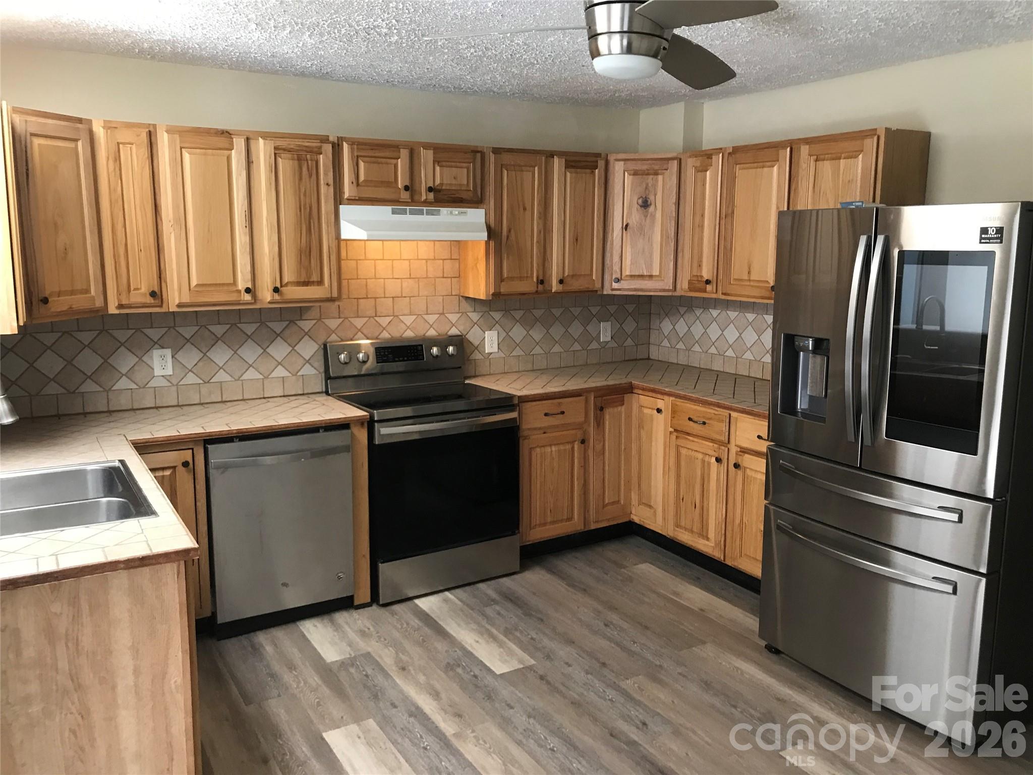 545 Avery Creek Road Arden, NC 28704 - Photo 6 of 35 a kitchen with a sink stove and refrigerator