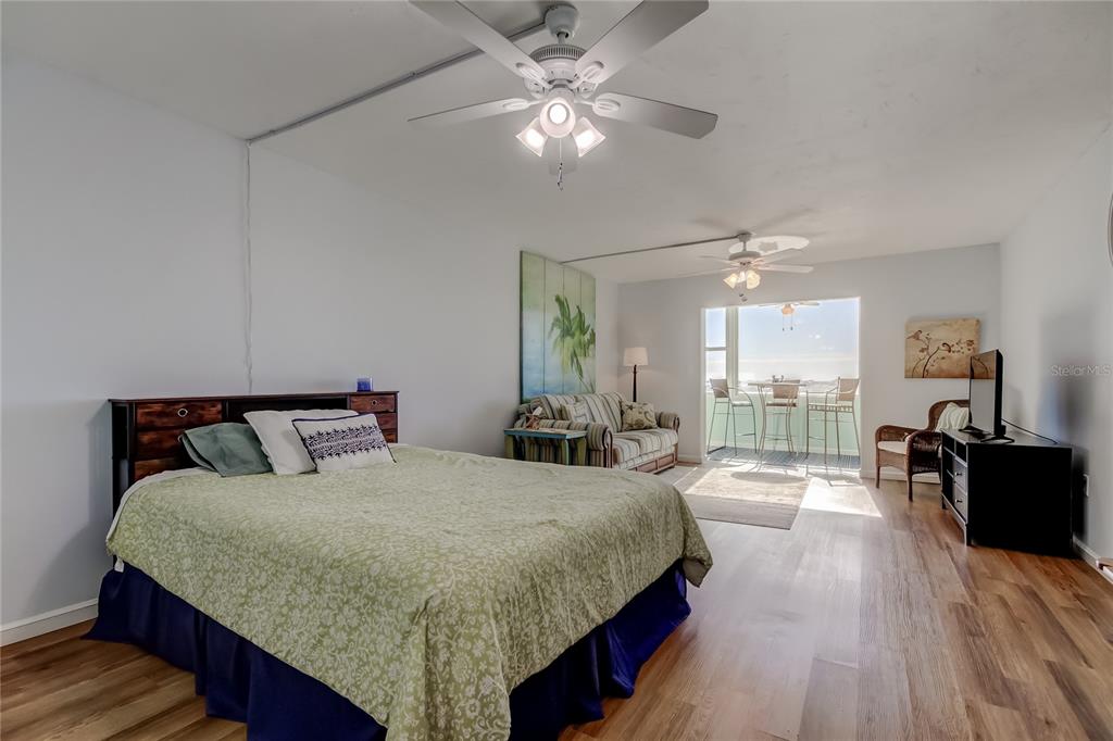 4775 Cove Circle, Unit 1105 St. Petersburg, FL 33708 - Photo 12 of 40 a bedroom with a large bed and a chandelier