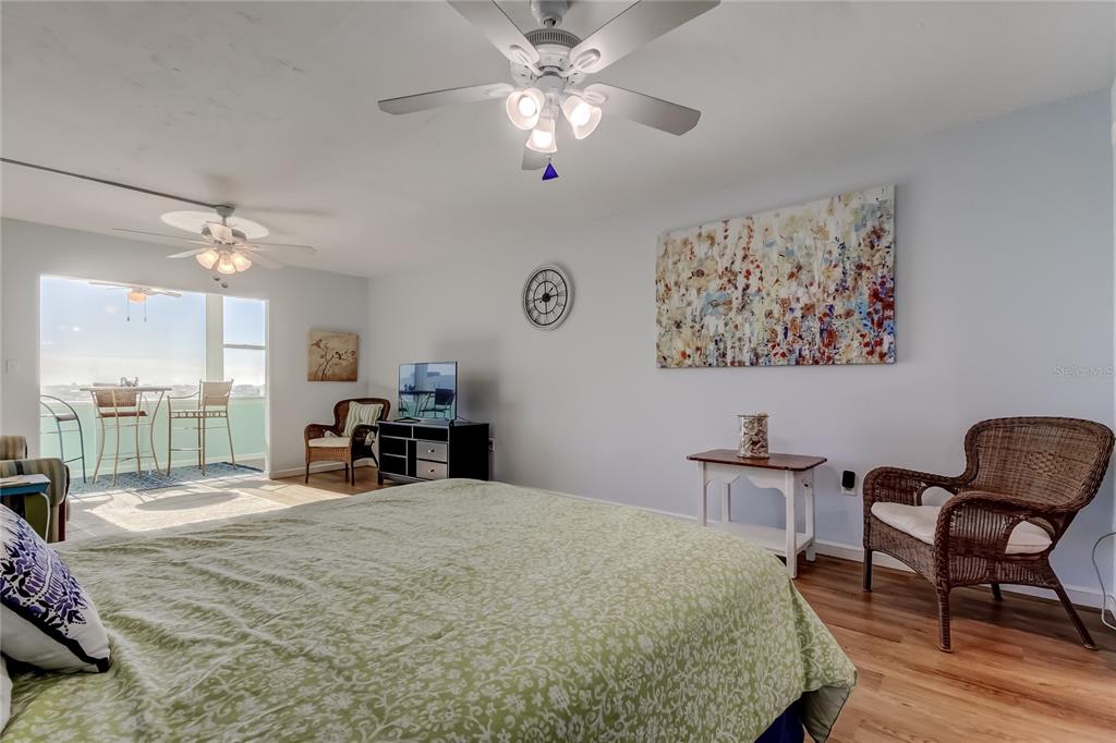 4775 Cove Circle, Unit 1105 St. Petersburg, FL 33708 - Photo 13 of 40 a bed room with a bed and a chair