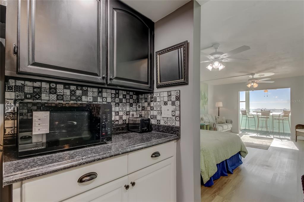 4775 Cove Circle, Unit 1105 St. Petersburg, FL 33708 - Photo 4 of 40 a kitchen with stainless steel appliances wooden cabinets and a counter top space