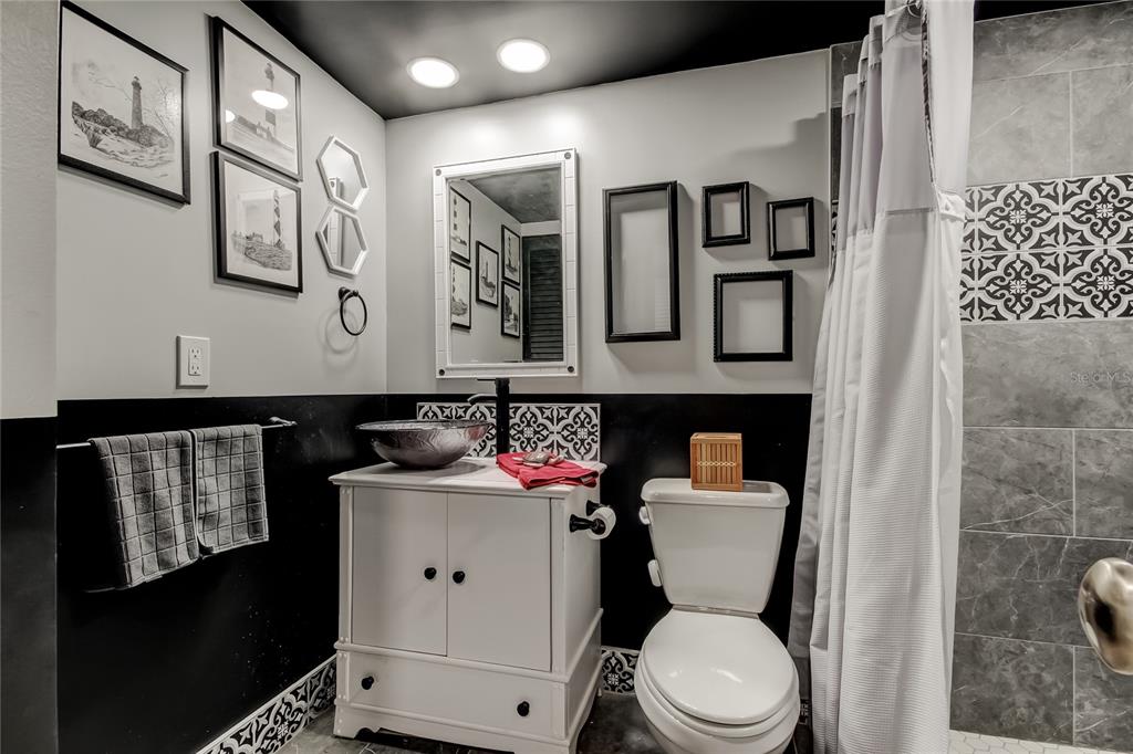 4775 Cove Circle, Unit 1105 St. Petersburg, FL 33708 - Photo 9 of 40 a bathroom with a toilet sink and mirror