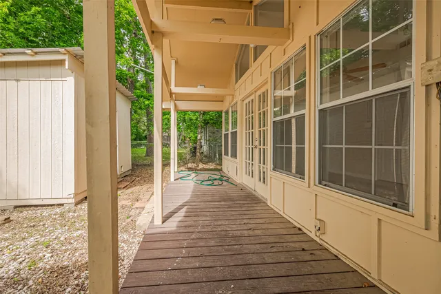 a view of a balcony with wooden floor and windows