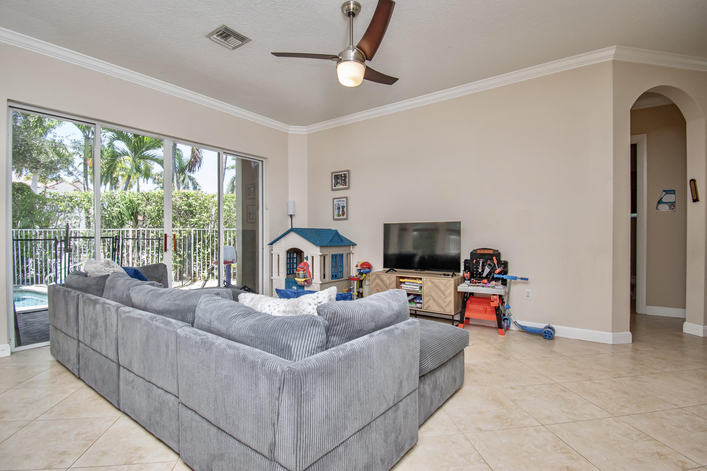 9851 Palma Vista Way Boca Raton, FL 33428 - Photo 12 of 33 a living room with furniture a flat screen tv and a large window