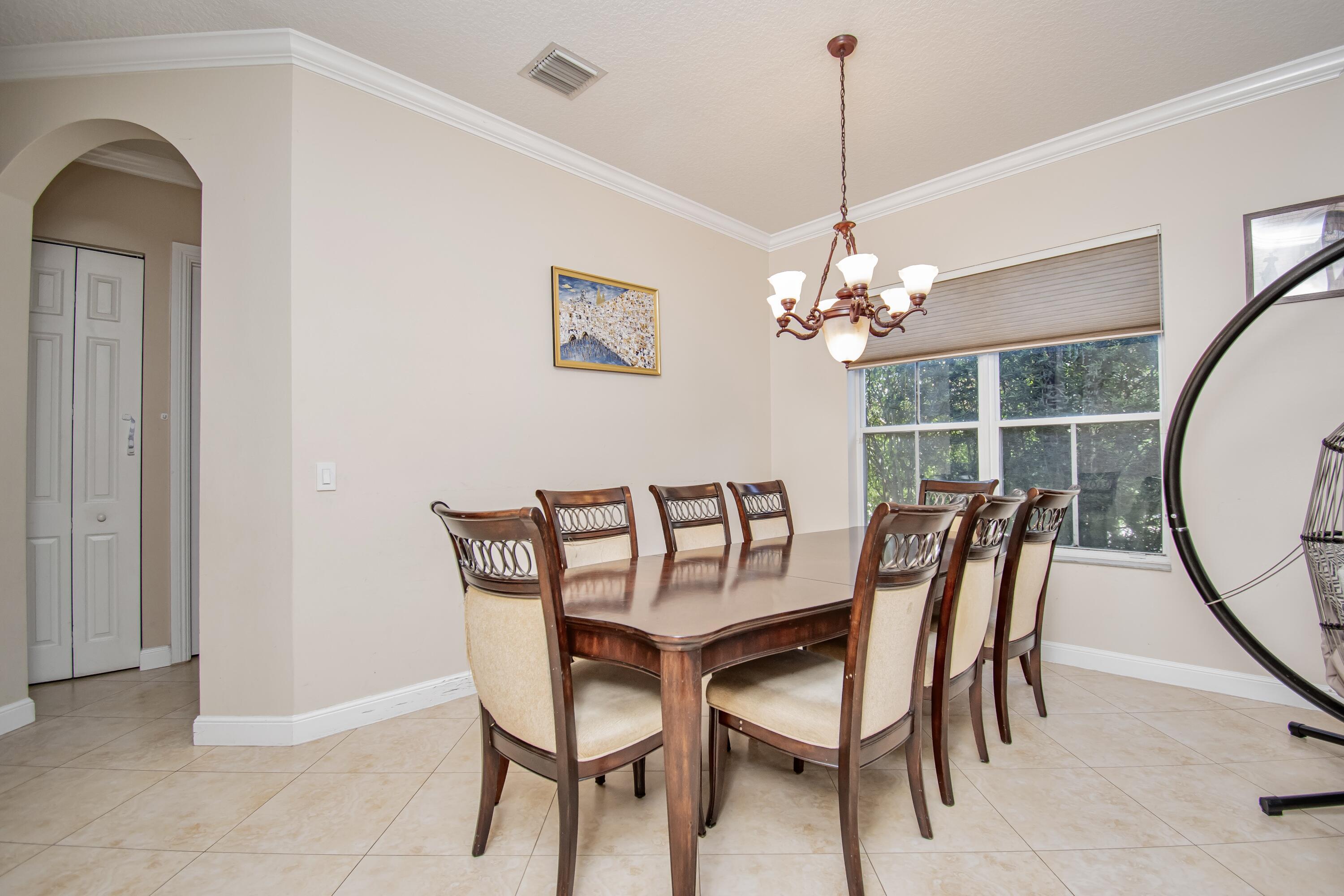 9851 Palma Vista Way Boca Raton, FL 33428 - Photo 10 of 33 a dining room with furniture a rug and a chandelier