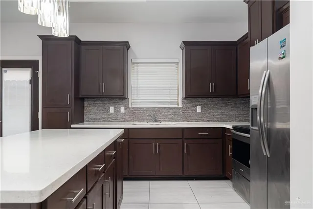 a kitchen with stainless steel appliances granite countertop a sink and a refrigerator
