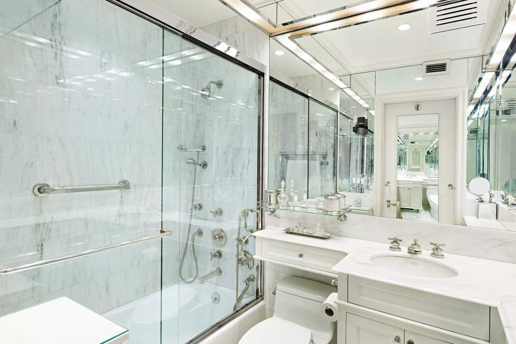 35 East 76th Street, Unit 1604 Manhattan, NY 10021 - Photo 4 of 10 a bathroom with a double vanity sink toilet mirror and shower