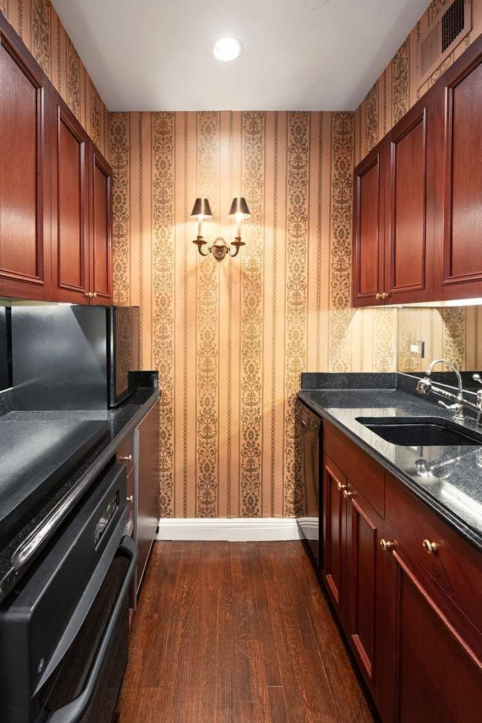 35 East 76th Street, Unit 1604 Manhattan, NY 10021 - Photo 6 of 10 a kitchen with wooden cabinets and a stove top oven