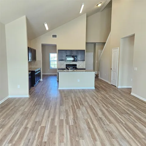 a large kitchen with cabinets wooden floor and stainless steel appliances