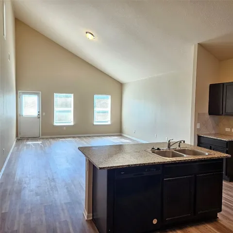 a room with a sink cabinets and wooden floor