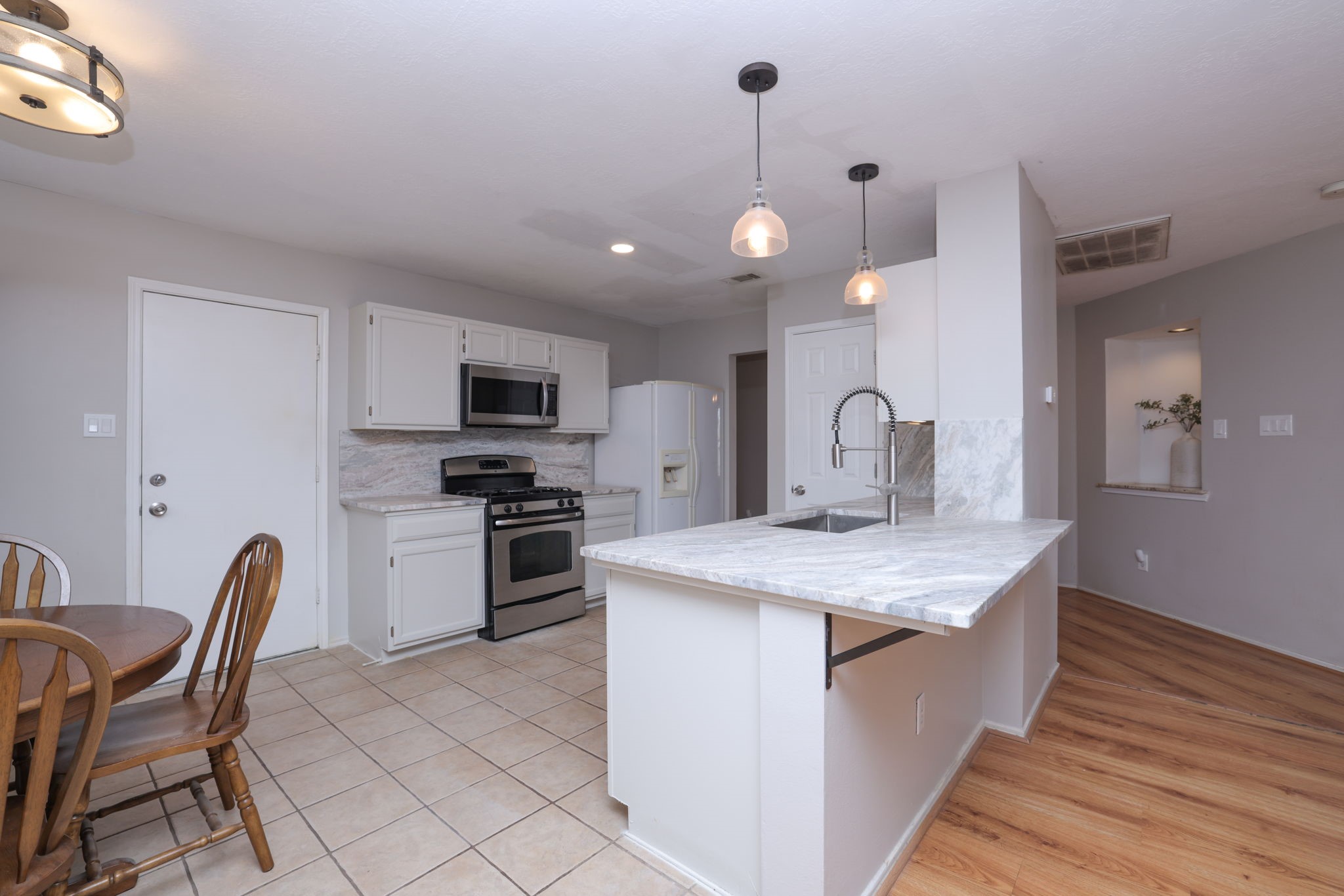 3803 Oaklace Drive Spring, TX 77389 - Photo 13 of 36 a kitchen with a sink stainless steel appliances and chairs