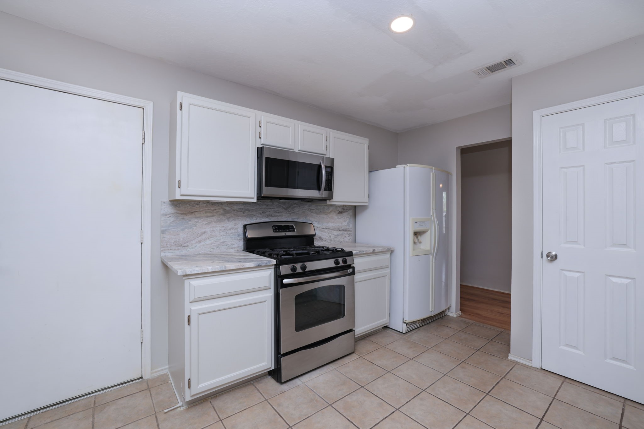 3803 Oaklace Drive Spring, TX 77389 - Photo 15 of 36 a kitchen with white cabinets stainless steel appliances and a sink