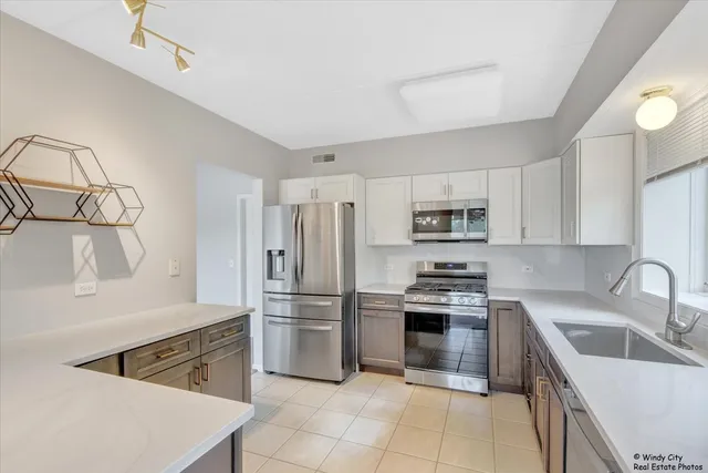 a kitchen with granite countertop a refrigerator stove and sink
