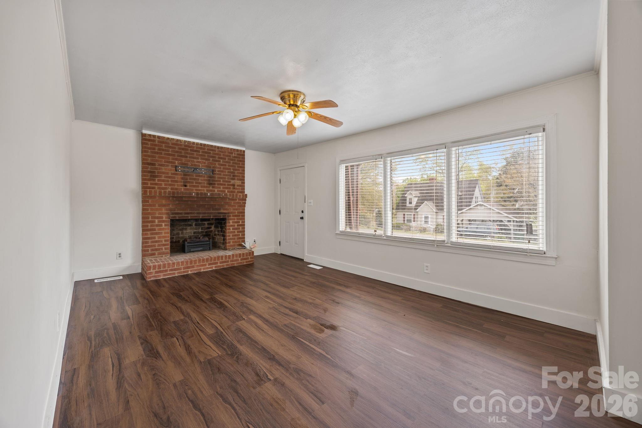 208 Ellis Street Albemarle, NC 28001 - Photo 7 of 38 an empty room with windows chandelier and wooden floor