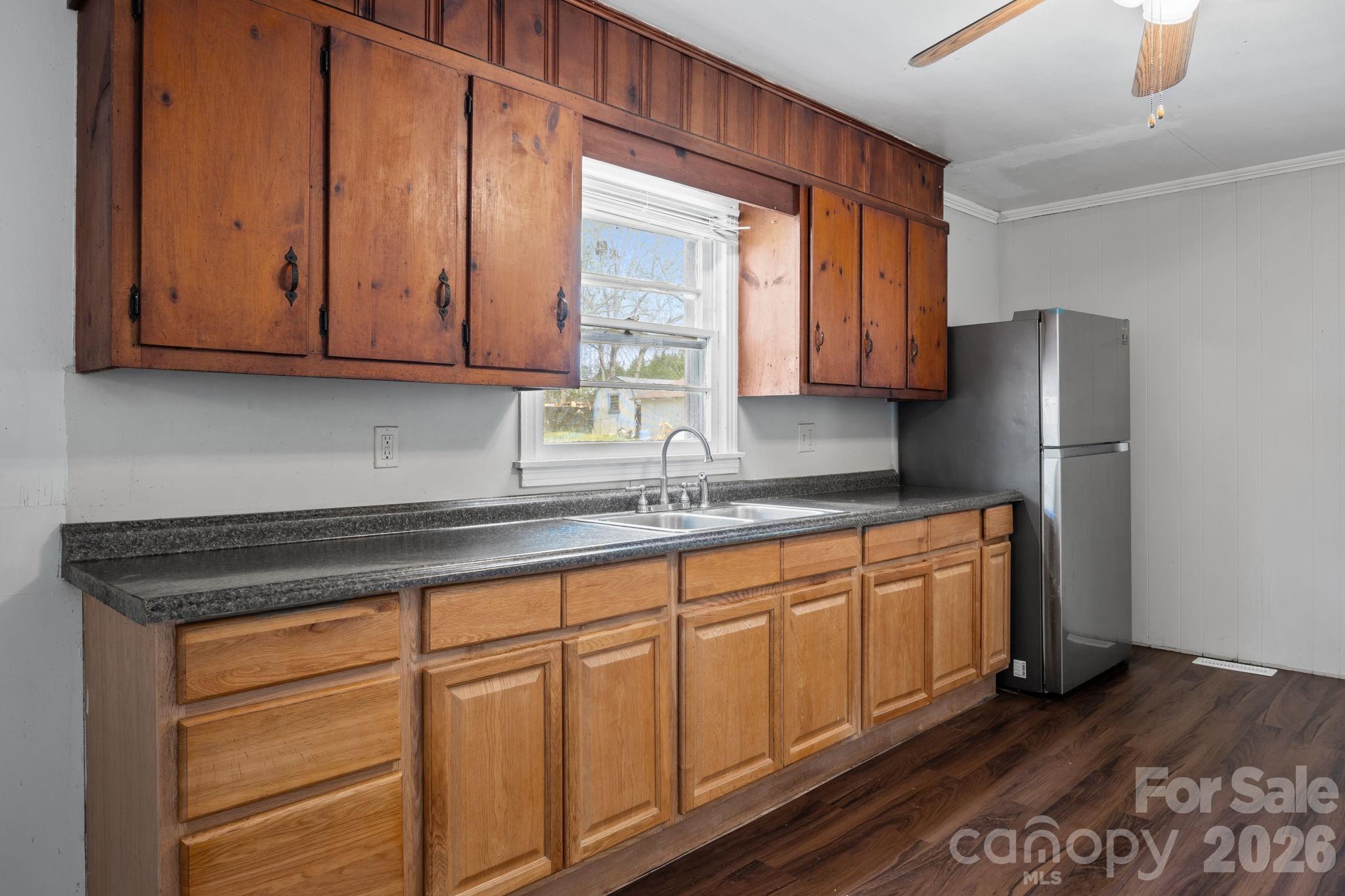 208 Ellis Street Albemarle, NC 28001 - Photo 9 of 38 a kitchen with stainless steel appliances granite countertop wooden cabinets a refrigerator and a sink