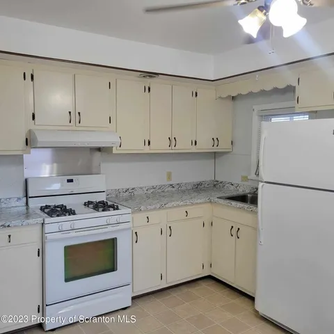 a kitchen with granite countertop white cabinets and white stove