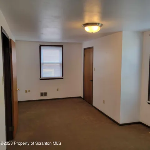 an empty room with a window and a ceiling fan