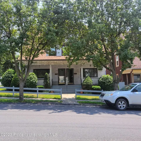 a view of a tennis ground with large trees
