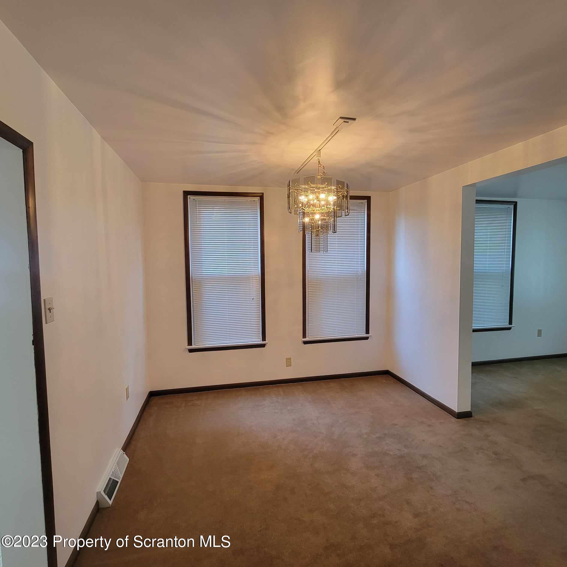 648 Prescott Avenue Scranton, PA 18510 - Photo 10 of 25 an empty room with chandelier fan and windows