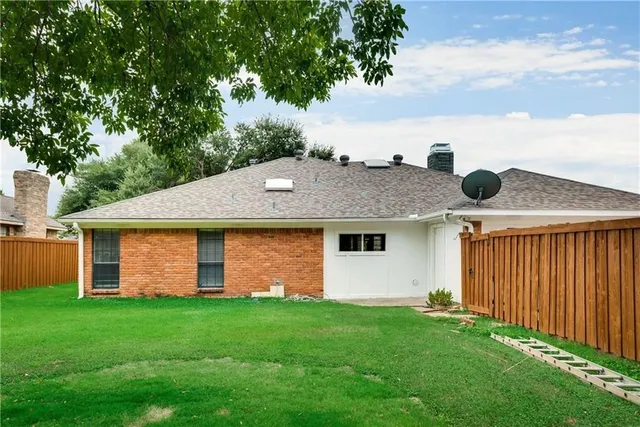 a front view of house with yard and trees in the background