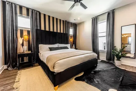 a bedroom with a bed a bookshelf and a flat tv screen