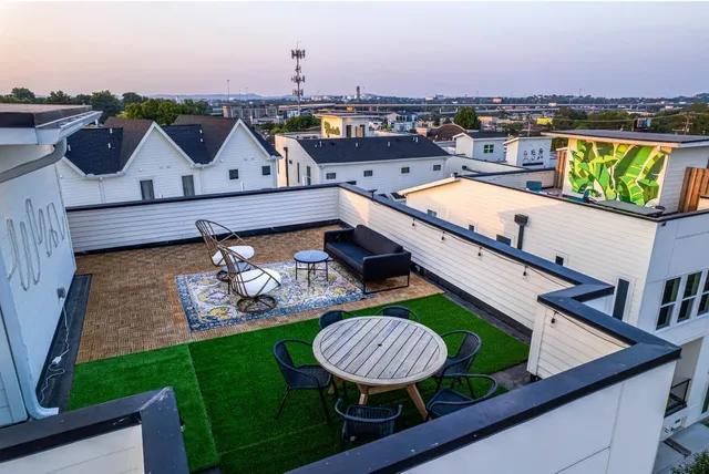 a view of a rooftop deck with couch and chairs