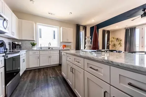 a kitchen with a sink window and cabinets