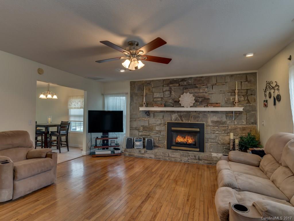 4361 Chimney Rock Road Hendersonville, NC 28792 - Photo 2 of 19 a living room with furniture a fireplace and a flat screen tv
