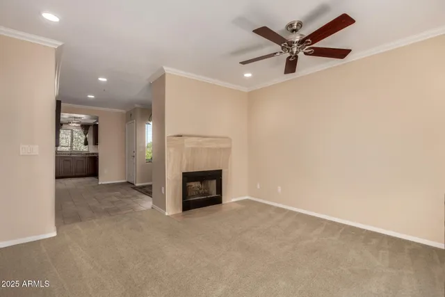 an empty room with a fireplace and fan