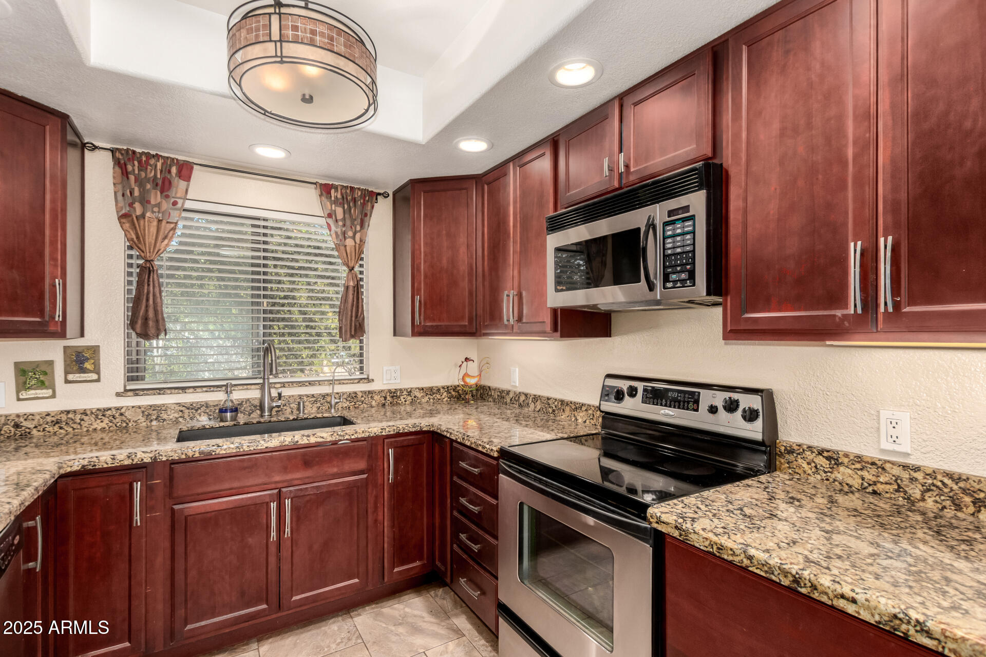 7575 East Indian Bend Road, Unit 2146 Scottsdale, AZ 85250 - Photo 6 of 40 a kitchen with granite countertop wooden cabinets stove top oven and microwave