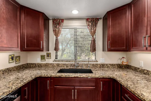 a kitchen with stainless steel appliances granite countertop wooden cabinets a sink and dishwasher