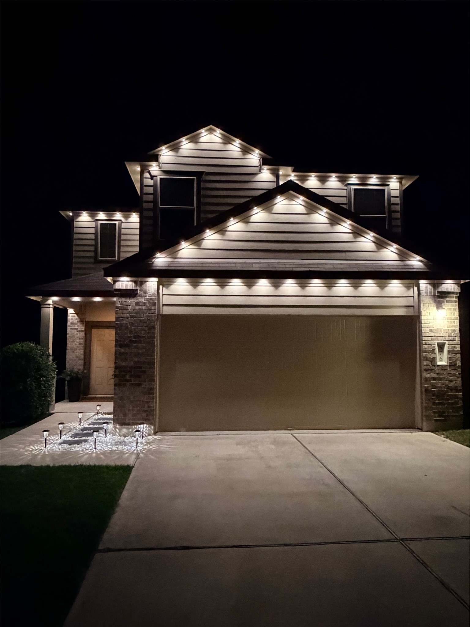 576 Greatest Gift Way Jarrell, TX 76537 - Photo 35 of 37 Elegant exterior lighting illuminates this home, highlighting the striking architectural details.