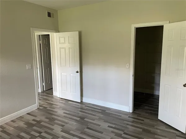 an empty room with wooden floor and closet