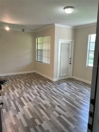 a view of a room with wooden floor and window