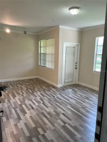 a view of a room with wooden floor and window