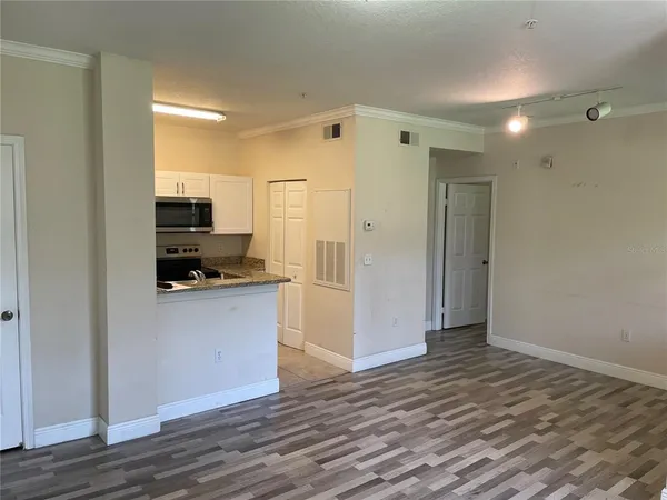 a open kitchen with white cabinets and wooden floor