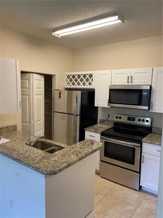 a kitchen with stainless steel appliances granite countertop a sink and a refrigerator
