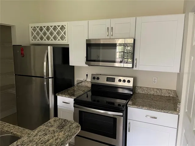 a kitchen with stainless steel appliances granite countertop a refrigerator stove and microwave