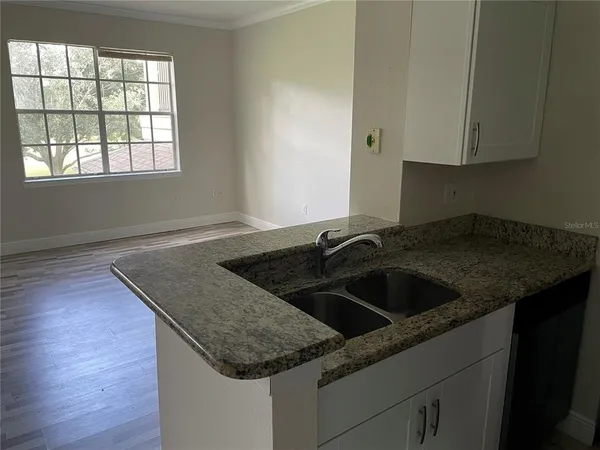 a kitchen with granite countertop a sink and a stove