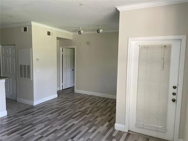 an empty room with wooden floor & closet area
