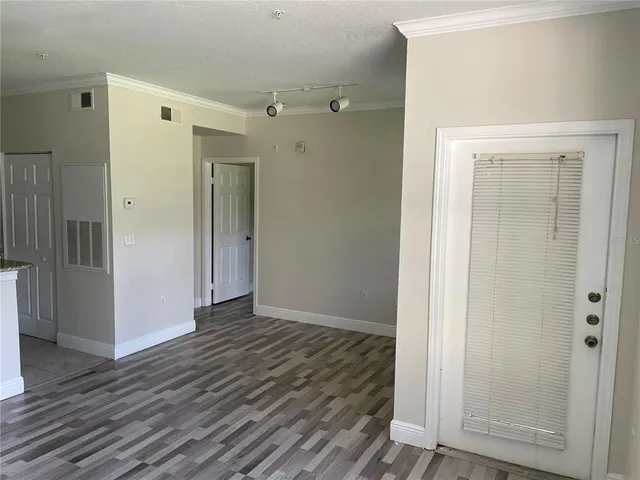 an empty room with wooden floor & closet area