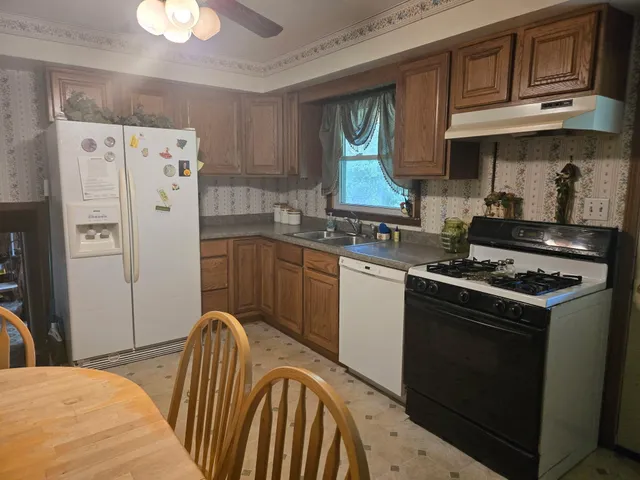 a kitchen with stainless steel appliances granite countertop a stove a sink dishwasher and a refrigerator